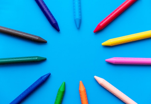 Цветные карандаши, образуя круг вид сверху на голубой фон