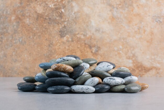 Colorful decorative stones for crafting on concrete background.