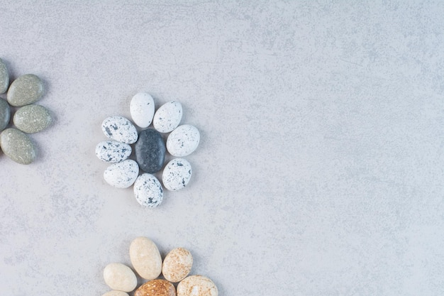 Colorful decorative stones for crafting on concrete background.