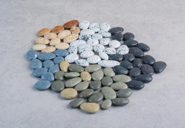 Colorful decorative stones for crafting on concrete surface.