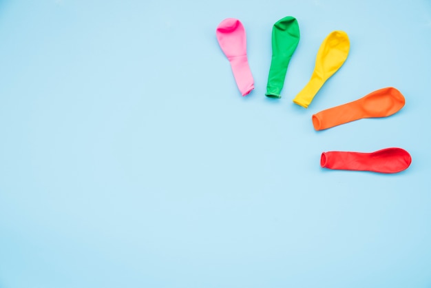 Colorful deflated balloons on blue background