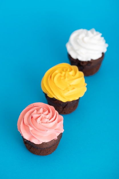 Colorful delicious cupcakes covered in frosting