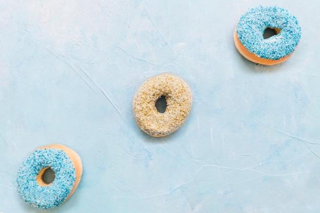 Colorful delicious donuts on blue background