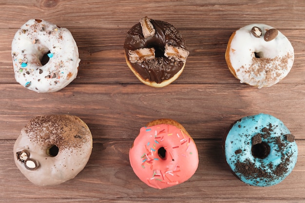 Colorful donuts on wooden background