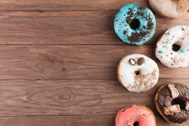 Colorful donuts on wooden blackboard