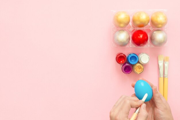 Colorful easter egg painted in pastel colors composition with paint brush