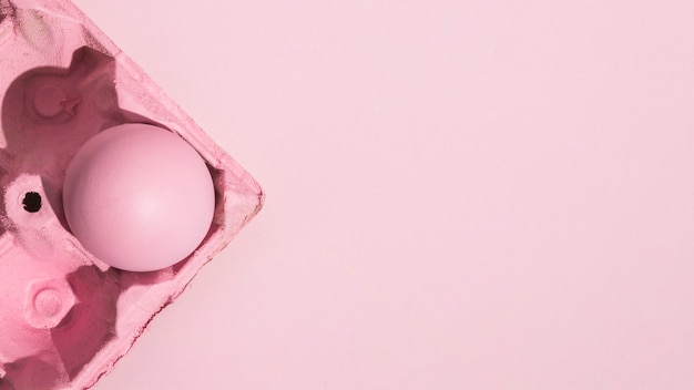 Free photo colorful easter egg in pink rack on pink table