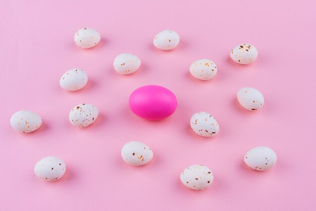 Colorful Easter egg with white eggs on table