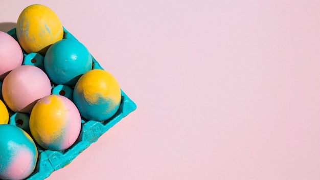 Colorful Easter eggs in blue rack on table