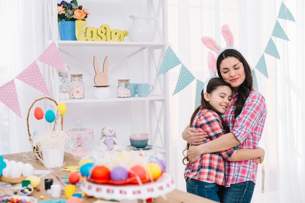 Colorful easter eggs in front of mother and daughter embracing each other