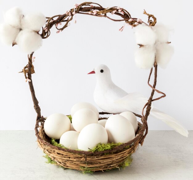 Colorful easter eggs in hay basket front view