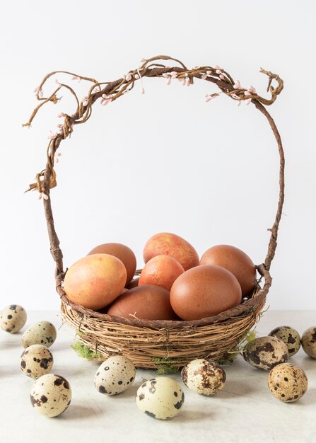 Foto gratuita uova di pasqua colorate nel cesto di fieno vista frontale