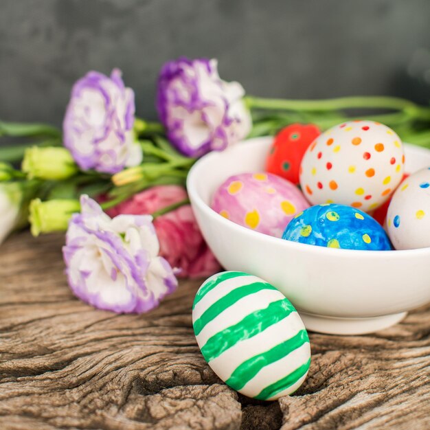 Colorful easter eggs and lisianthus on wooden table