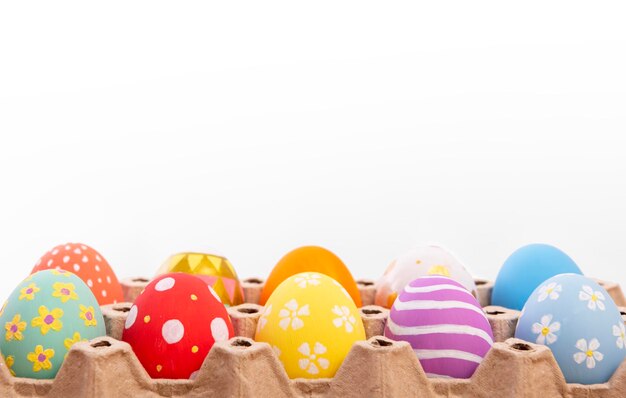 Colorful easter eggs in nest on white copy space background