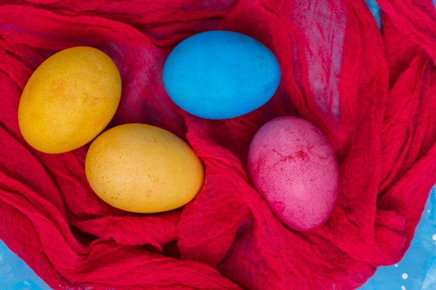 Foto gratuita uova di pasqua colorate sul panno rosso