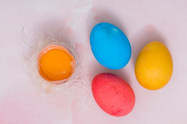 Colorful Easter eggs with broken egg in nest