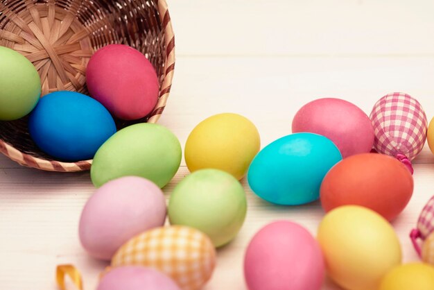 Colorful eggs scattering from a wicker bowl
