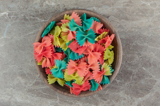 Colorful farfalle pasta in wooden bowl