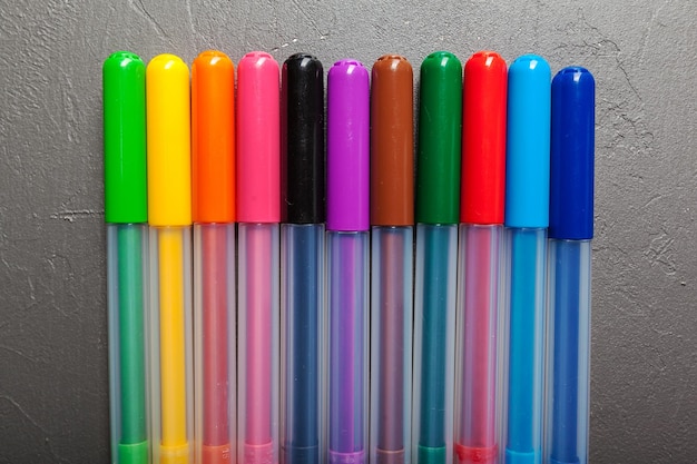 Colorful felt pens on the dark stone background top view