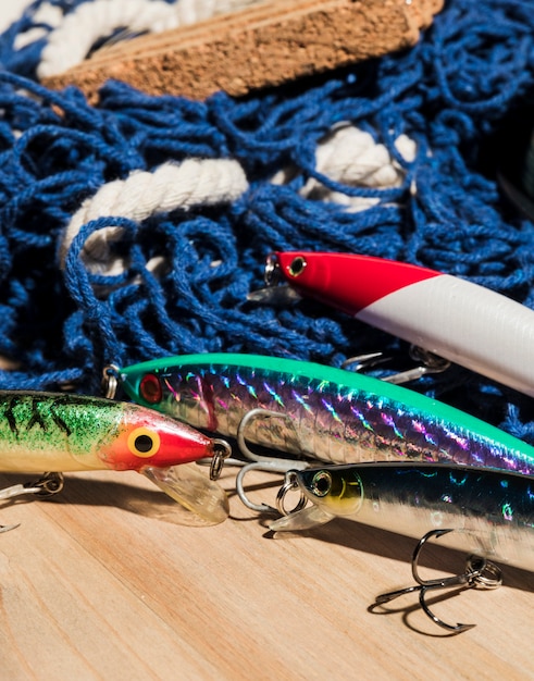 Colorful fishing baits with net on wooden desk
