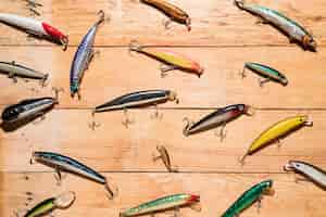 Бесплатное фото Красочные рыболовные приманки на деревянный стол
