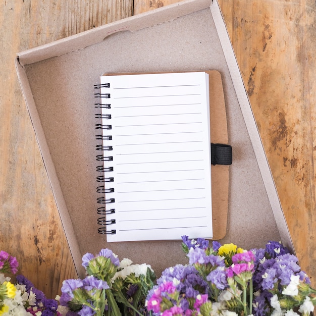 Colorful flowers near diary in box