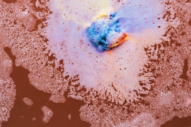 Colorful foam on brown water