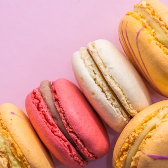 Colorful french cookies macarons on pink background tasty fruit almond sweet cookies cake macaron