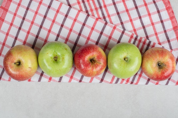 縞模様のテーブルクロスにカラフルな新鮮なリンゴ