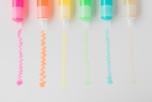 Free photo colorful gel tubes squeezed on white sheet of paper background