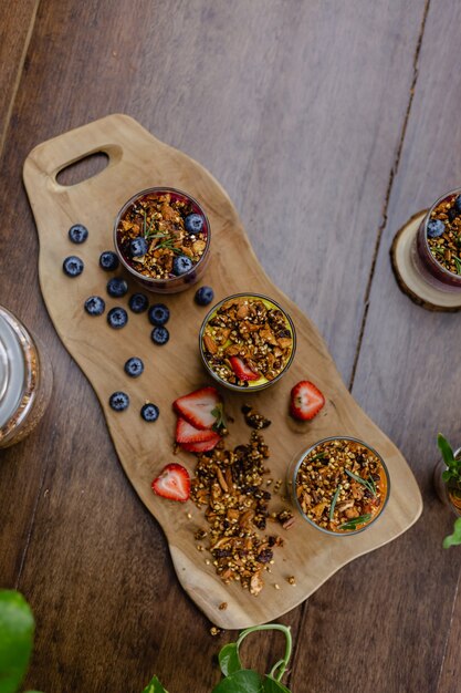 Colorful healthy breakfast sweet deserts few different chia puddings in glass jars on wooden table in kitchen at home.