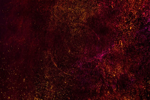 Colorful holi powder particles over black background