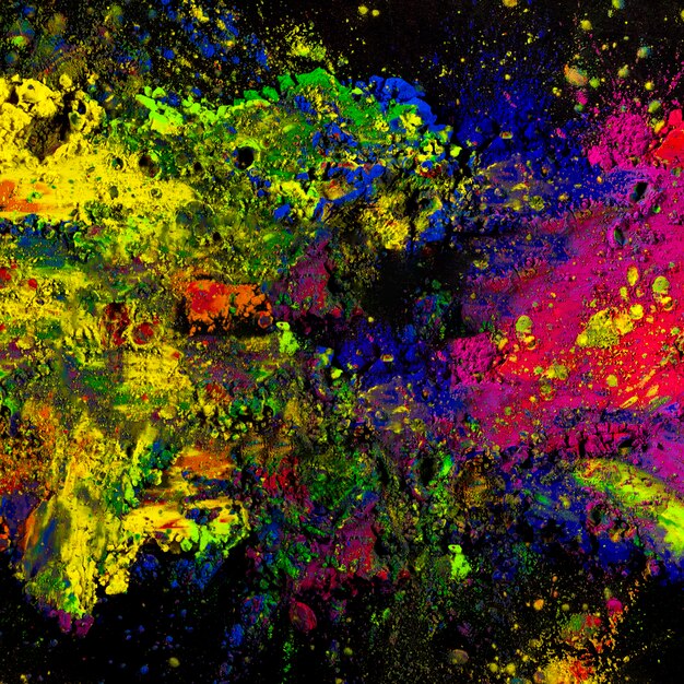 Colorful holi powder splatted on black backdrop