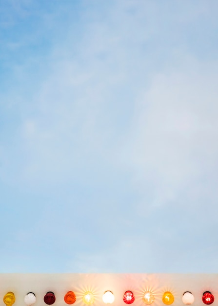 Free photo colorful illuminated light bulbs against blue sky