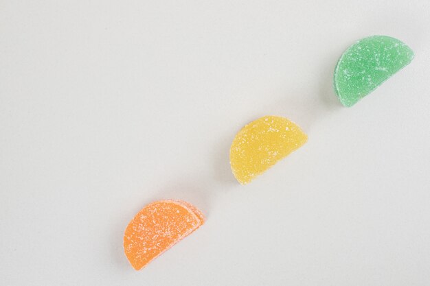 Colorful jelly candies on white surface