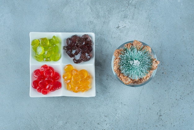 Free photo colorful jelly candies with a christmas tree on marble.