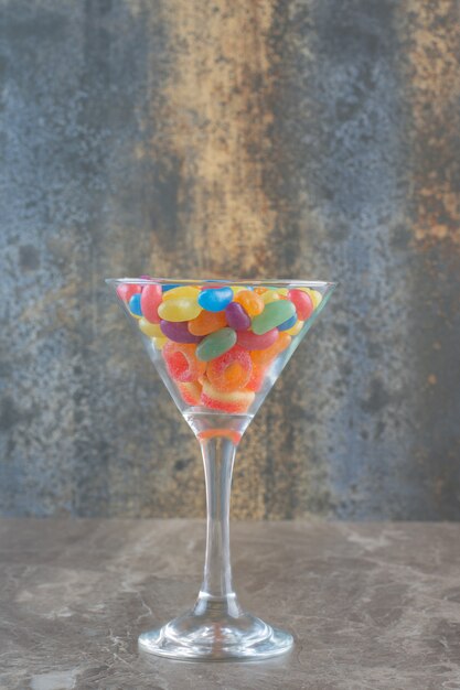 Colorful jellybeans in glass, Vertical photo. 