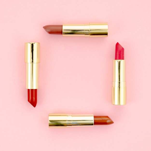 Colorful lipsticks on pink background