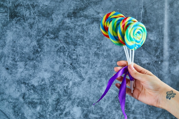 Free photo colorful lollipops on marble background.