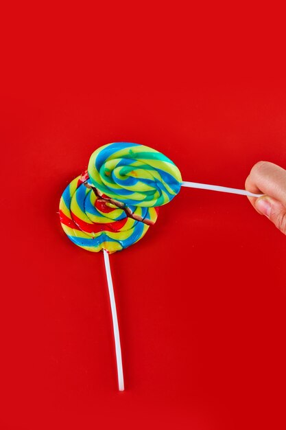 Colorful lollipops on red surface.