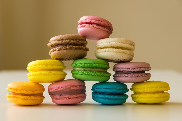 Colorful macarons stacked in a pyramid form on a white table