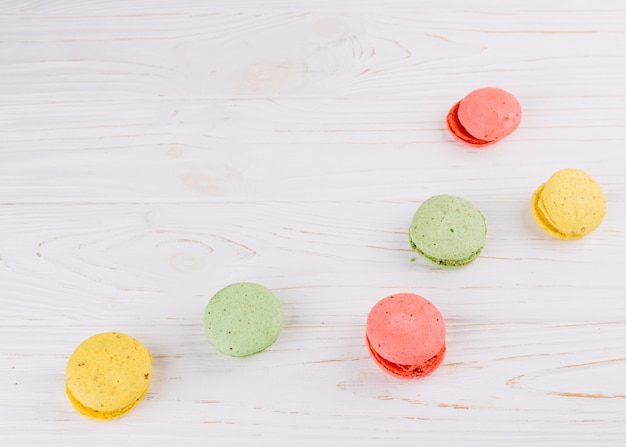 Colorful macaroons on wooden textured backdrop