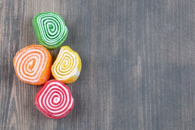 Colorful marmalade candies on wooden surface