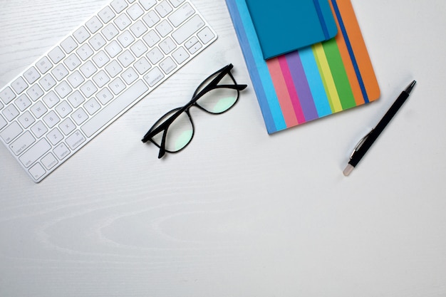 Colorful notepad glasses pen and keyboard