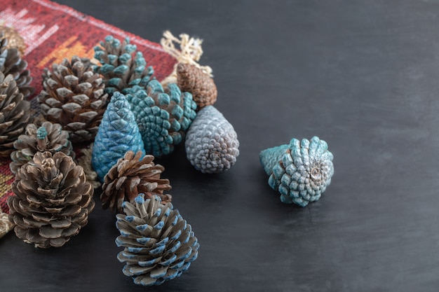 Colorful oak tree cones on a piece of red pattern ethnic rug