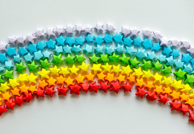 Colorful origami stars forming a rainbow background