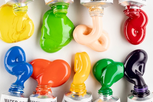 Colorful paint tubes on white table