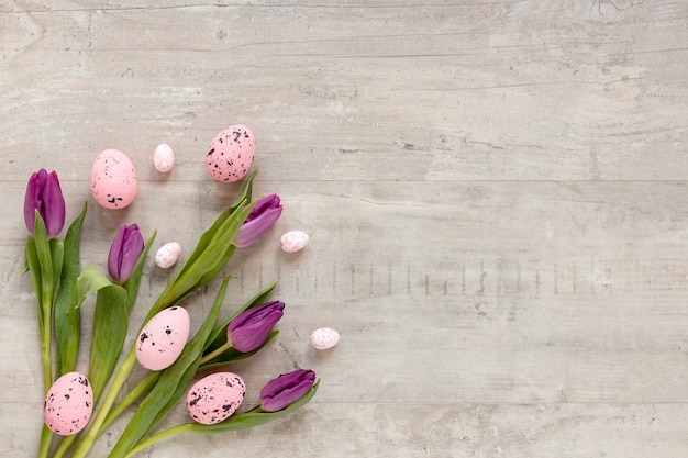 Бесплатное фото Красочные расписные яйца на пасху рядом с цветами