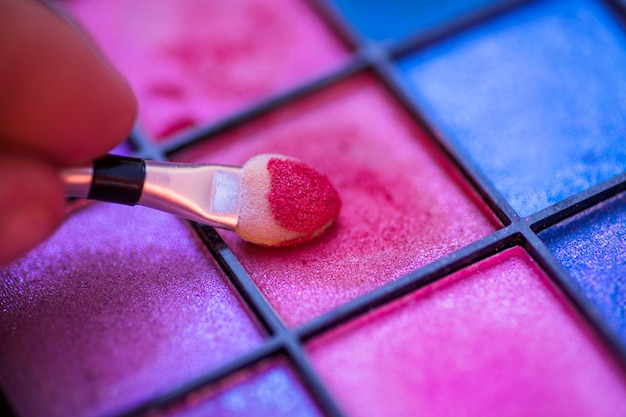 Colorful palette for makeup with hand holding brush