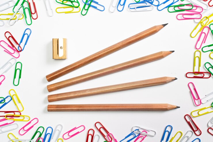 Free Photo colorful paper clips around and wooden pencils in the centre of composition isolated on white.